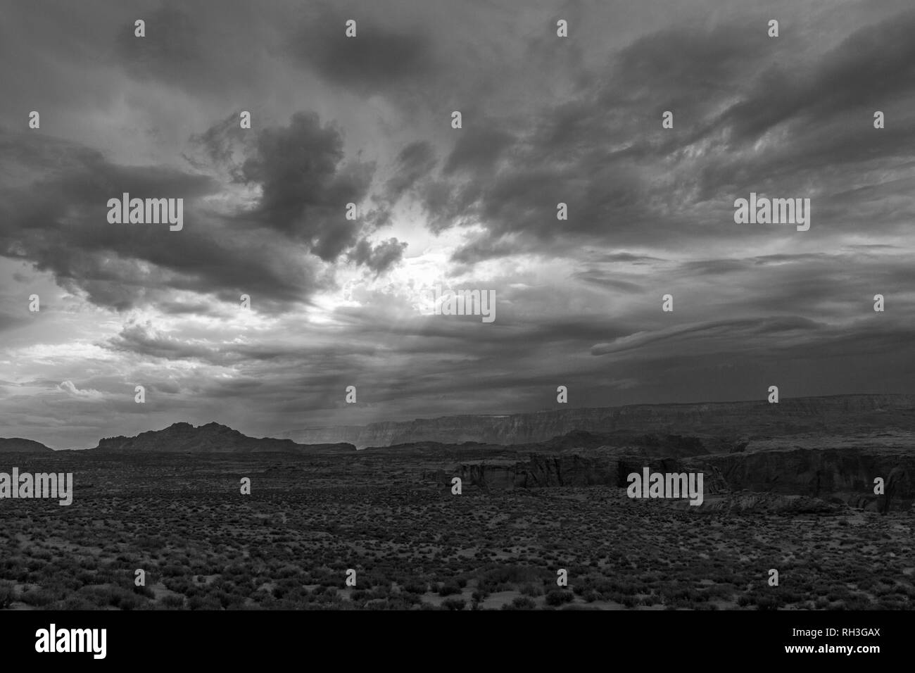 Dunkle Wolken und Sonnenstrahlen (B&W) über der Wüste in der Nähe von Horseshoe Bend auf dem Colorado River, in der Nähe von Page, Arizona, United States. Stockfoto