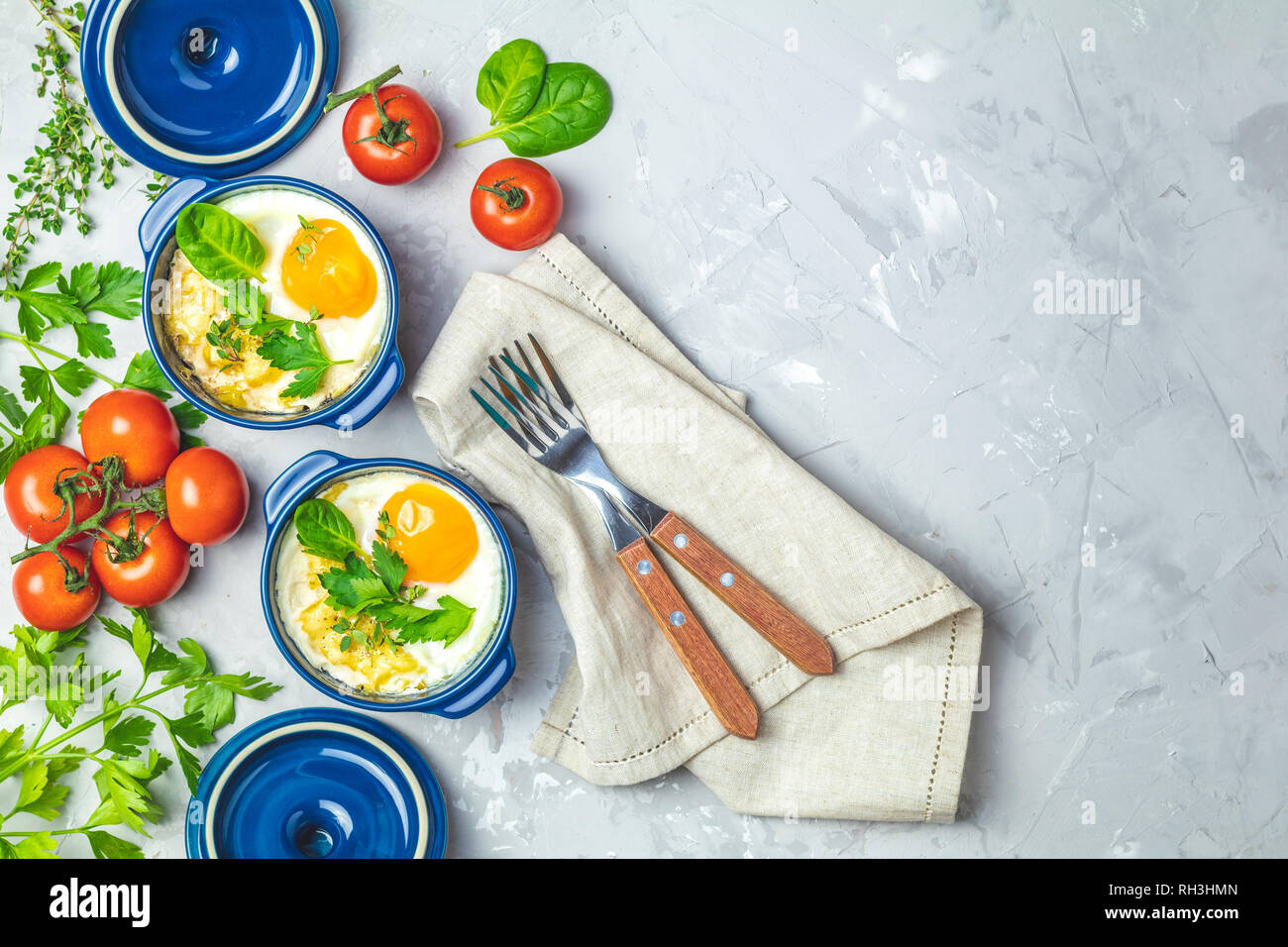 Gebackene Eier in blau Keramik Backformen. Portioniert Auflauf aus Gemüse und Eier in der italienischen oder französischen Stil. Eier kokot cocotte Frühstück. Top Stockfoto