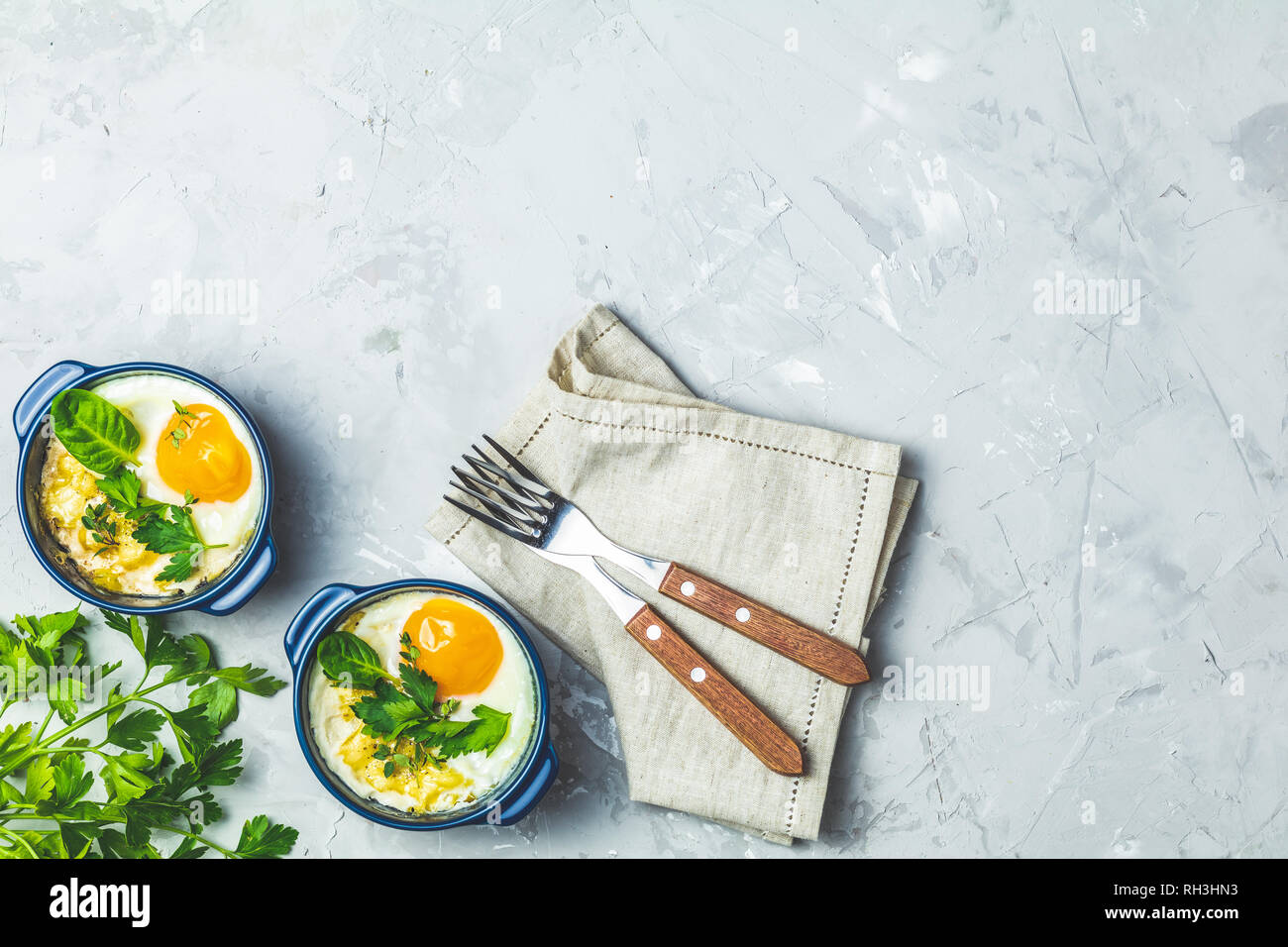 Gebackene Eier in blau Keramik Backformen. Portioniert Auflauf aus Gemüse und Eier in der italienischen oder französischen Stil. Eier kokot cocotte Frühstück. Top Stockfoto