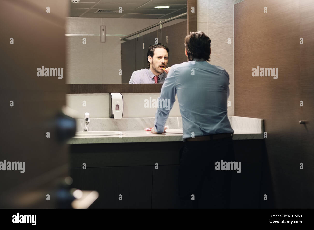 Business Mann Zähneputzen nach der Mittagspause im Büro Bad Stockfoto