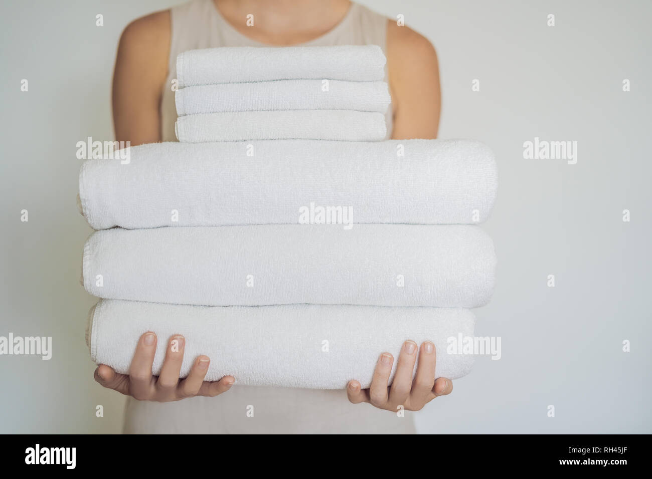 Eine Frau hält ein weißer Bettwäsche. Konzept der Service in Hotels, Wäscherei, Spa Stockfoto