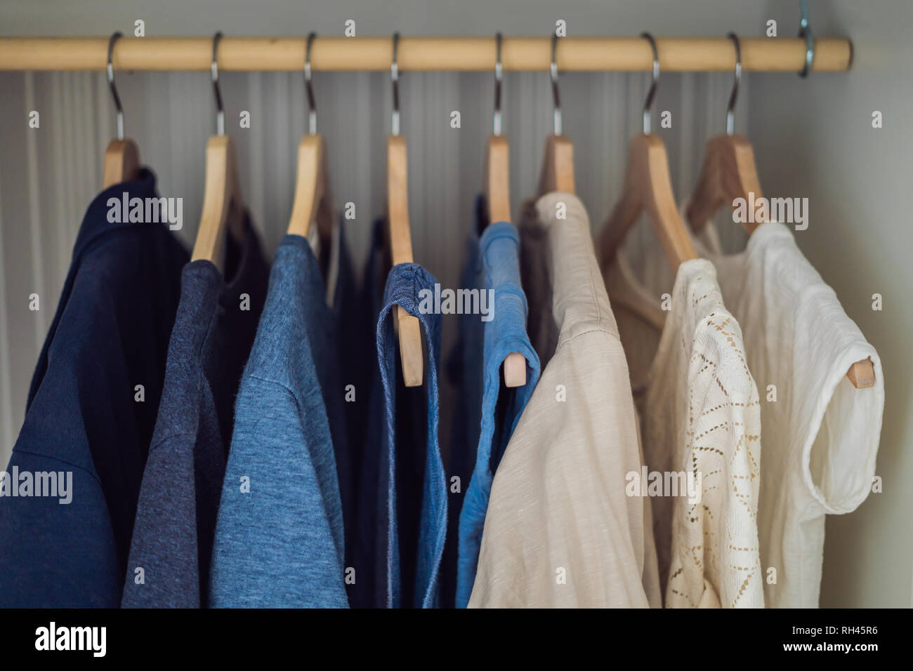 Kleidung auf Kleiderbügel im Schrank Farbverlauf von Weiß bis Dunkelblau  Stockfotografie - Alamy