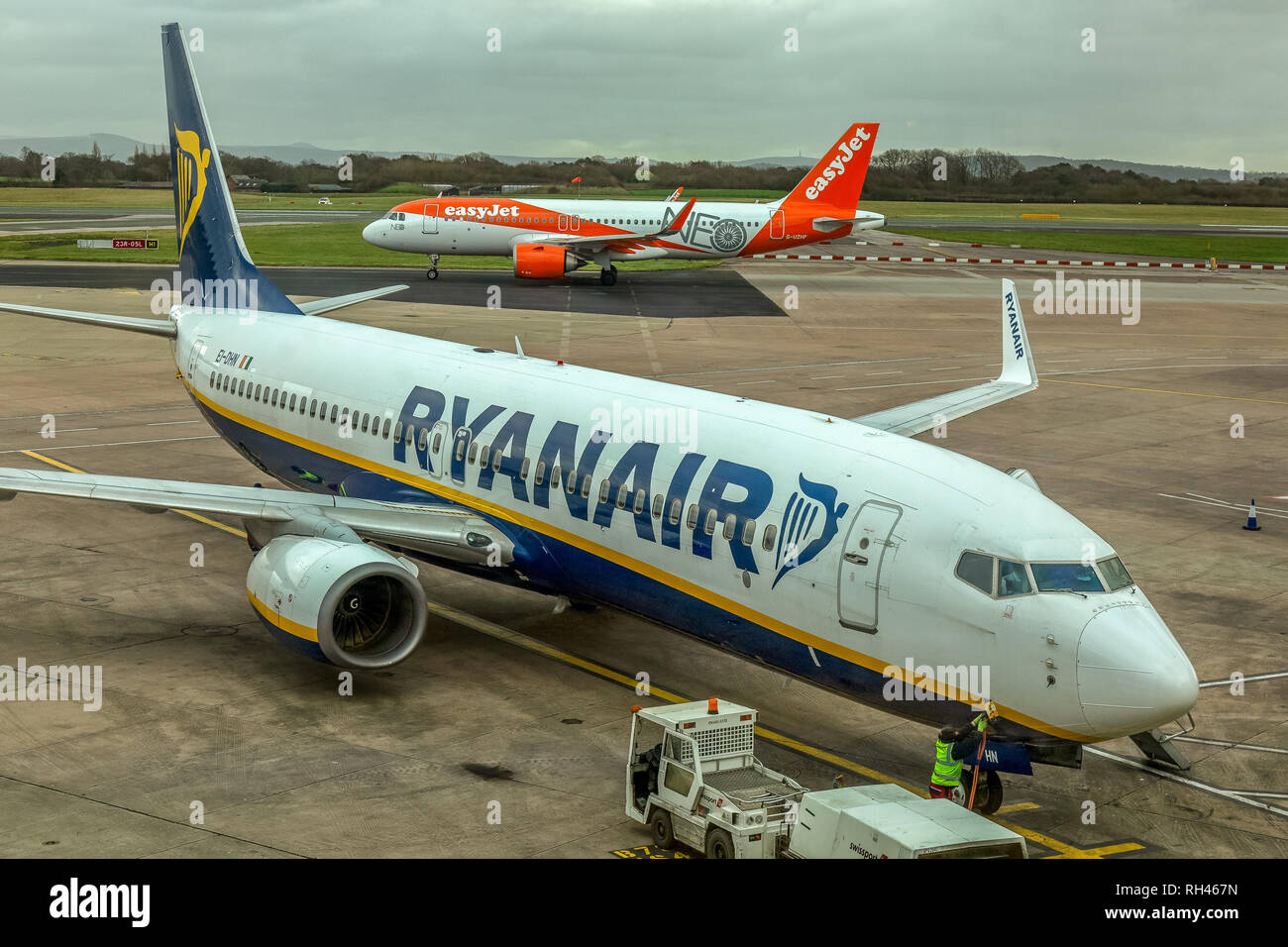 Eine Ryanair Boeing 737-800 Passagierflugzeug, mit einem easyjet Airbus Flugzeugen hinter, auf dem Flughafen Manchester. Stockfoto