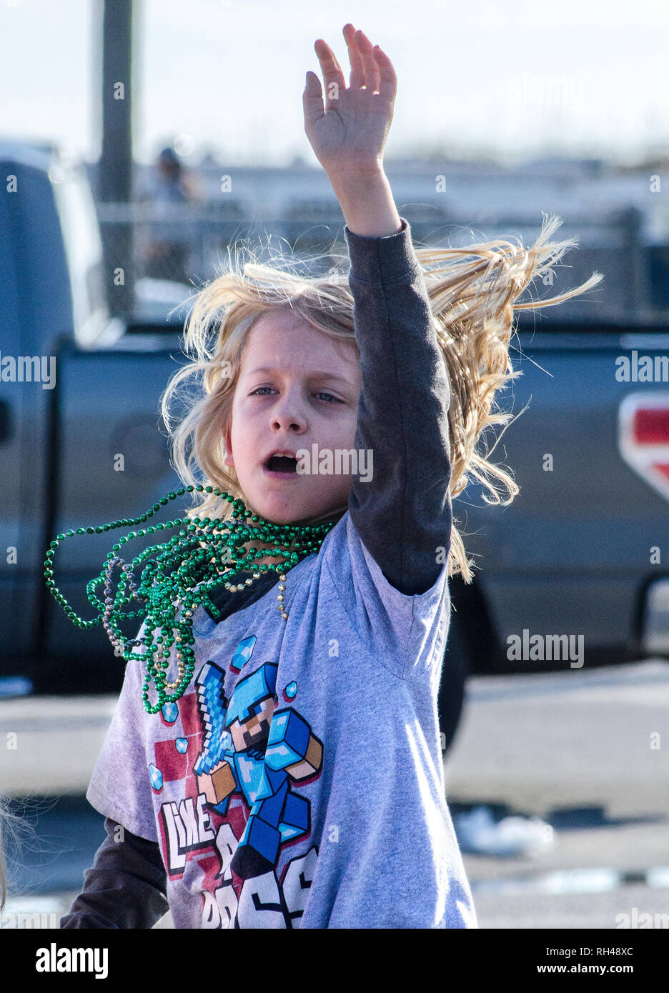 Ein Kind Wellen wie die Krewe de La Dauphine Parade rollt durch Dauphin Island, Alabama, Jan. 17, 2015, zum Auftakt des Mobile Mardi Gras Saison. Stockfoto