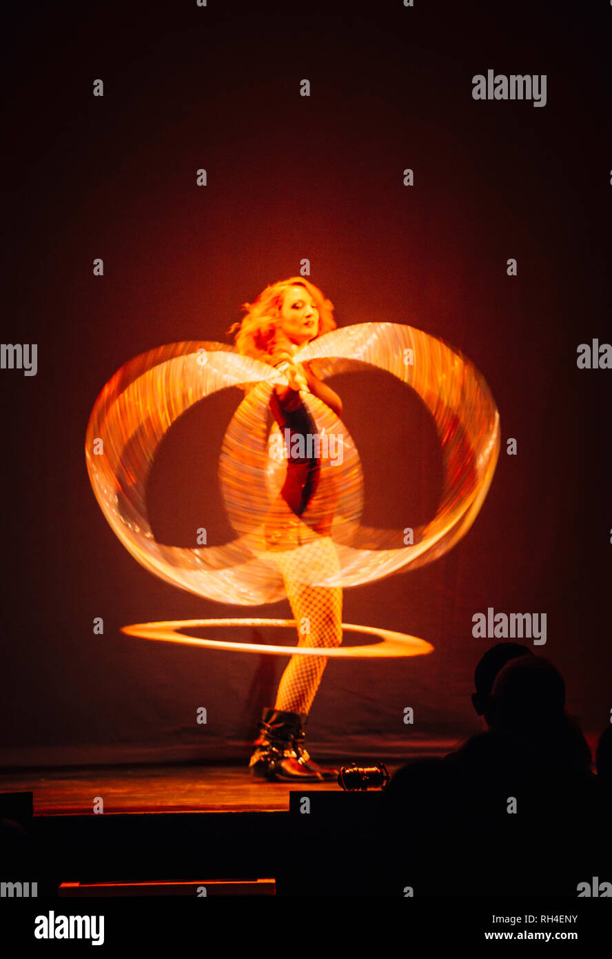 Frau auf der Bühne, Spinning beleuchtete Ringe Stockfoto