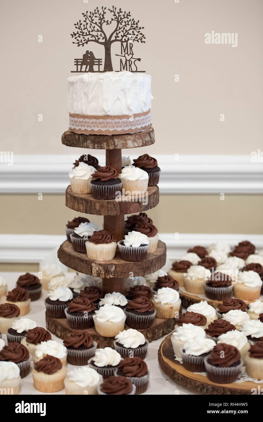 Hochzeitstorte & Cupcakes bei einer rustikalen, thematisch gestaltete Empfangs-Party Stockfoto