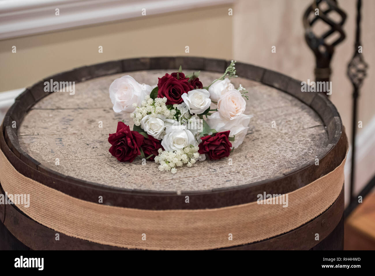 Brautblumenarrangement auf einem rustikalen Holzfass bei einem Hochzeitsempfang in einem Catering-Saal Stockfoto