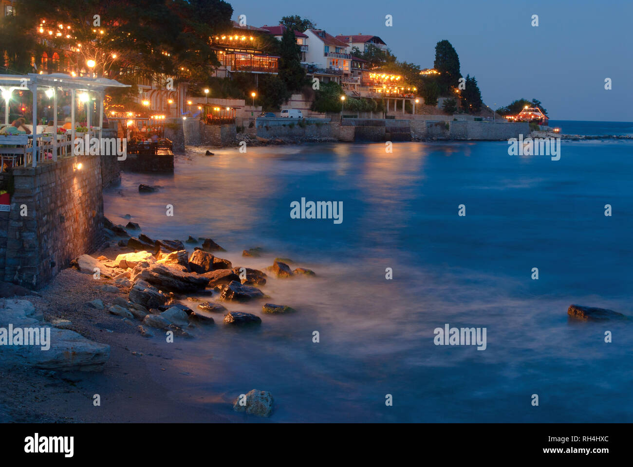 Nidht Blick auf Meer surfen Sie auf Steine an der alten Küstenstadt Stockfoto