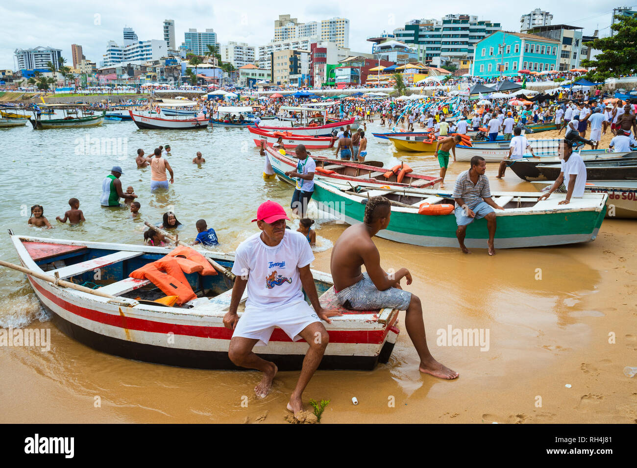 SALVADOR, Brasilien - Februar 02, 2016: Fischer im Dorf Rio Vermelho ihren Fischerbooten bieten zu Feiernden auf dem Festival von yemanja. Stockfoto
