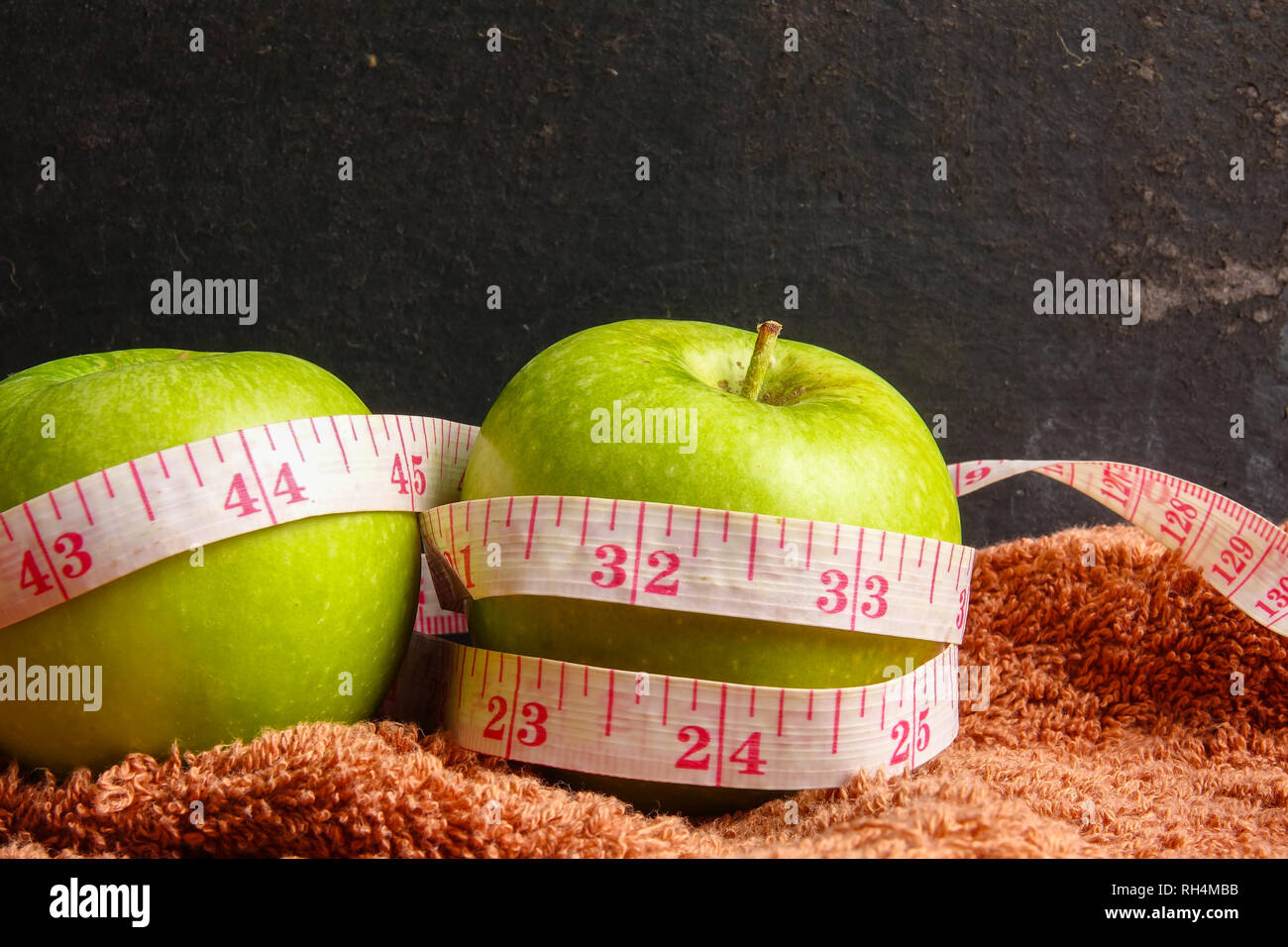 Gesundheit LIFESTYLE KONZEPT: Grüne Äpfel und Maßband in schwarz im  Hintergrund. Selektive konzentrieren Stockfotografie - Alamy
