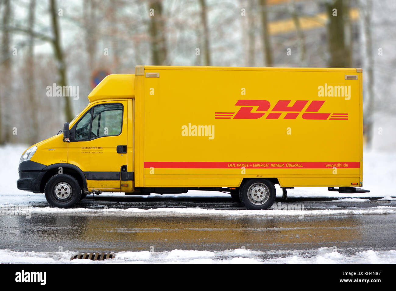 Gelbe DHL International Courier und Parcel deliivery Service-Lkw im Schnee in Deutschland Stockfoto