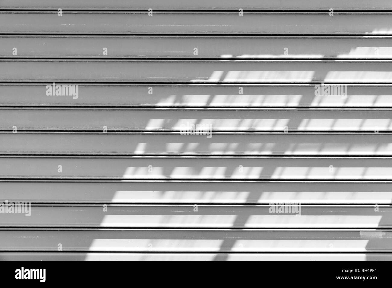 White Metal Rolltor mit Schatten Muster. Hintergrund Foto Textur, Vorderansicht Stockfoto