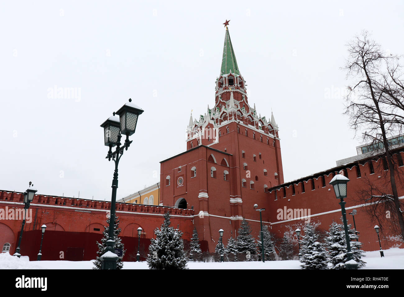 Moskauer Kreml und Schnee Tannen in bewölkten Tag bedeckt, malerischen Blick. Troitskaya Turm mit rotem Stern und Straßenlaternen im Alexandergarten Stockfoto