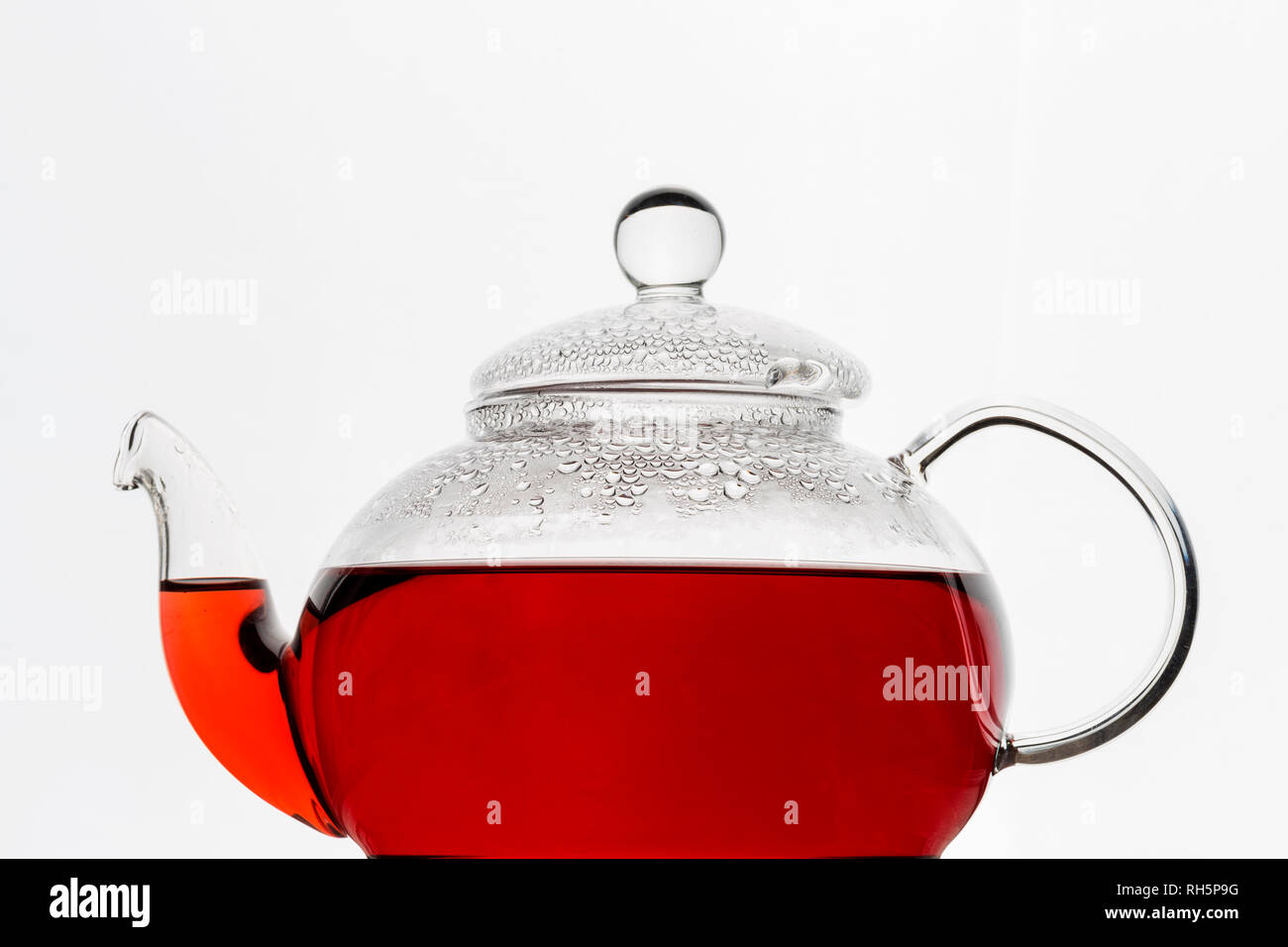 Transparenz Teekanne aus Glas mit roter Hibiskus karkade Tee auf weißen Hintergrund. Close Up, Menü, freier Speicherplatz Stockfoto