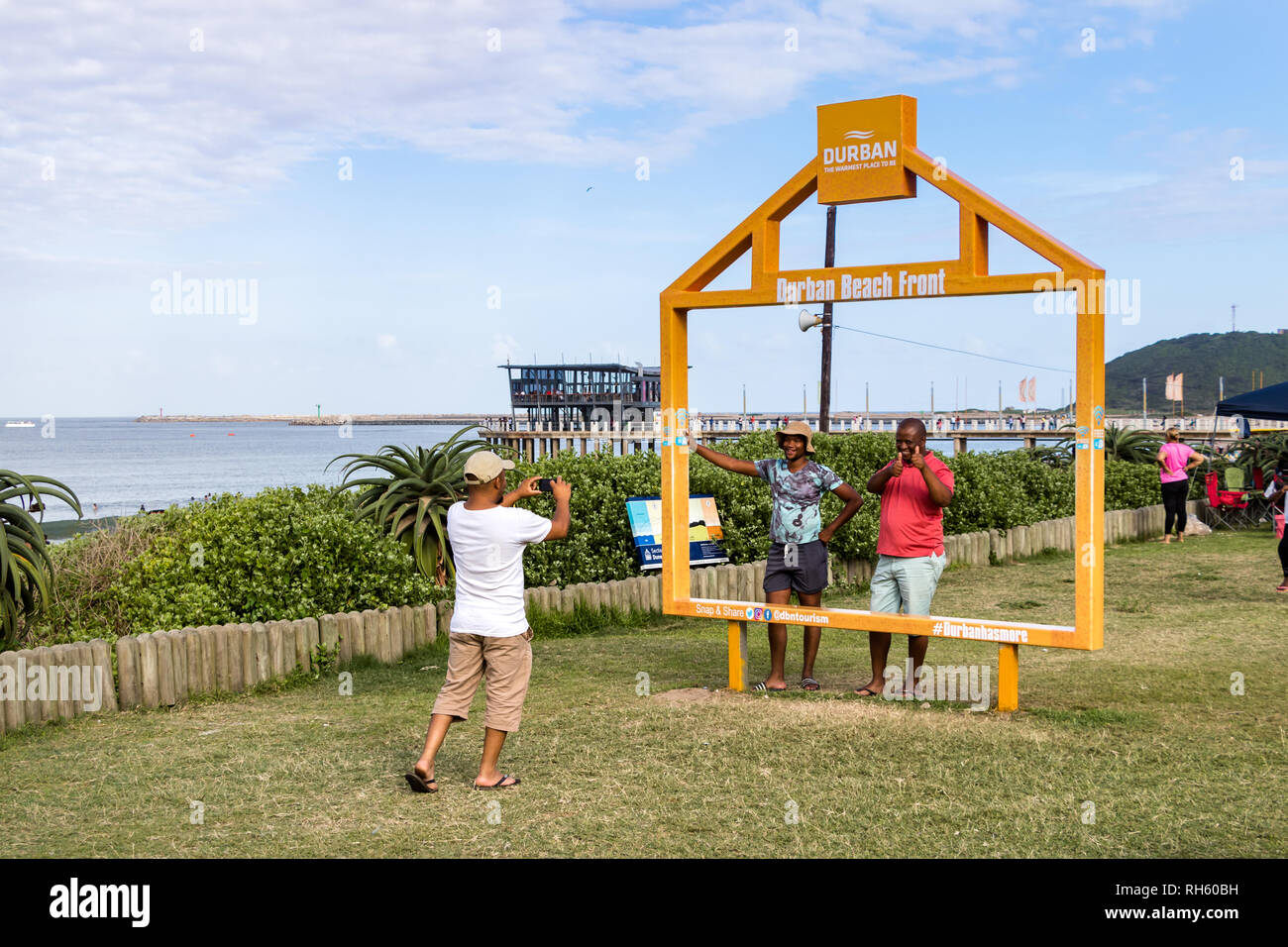 Durban, Südafrika - Januar 6th, 2019: Leute die Bilder auf einem großen Rahmen am Strand von Durban, Südafrika. Stockfoto