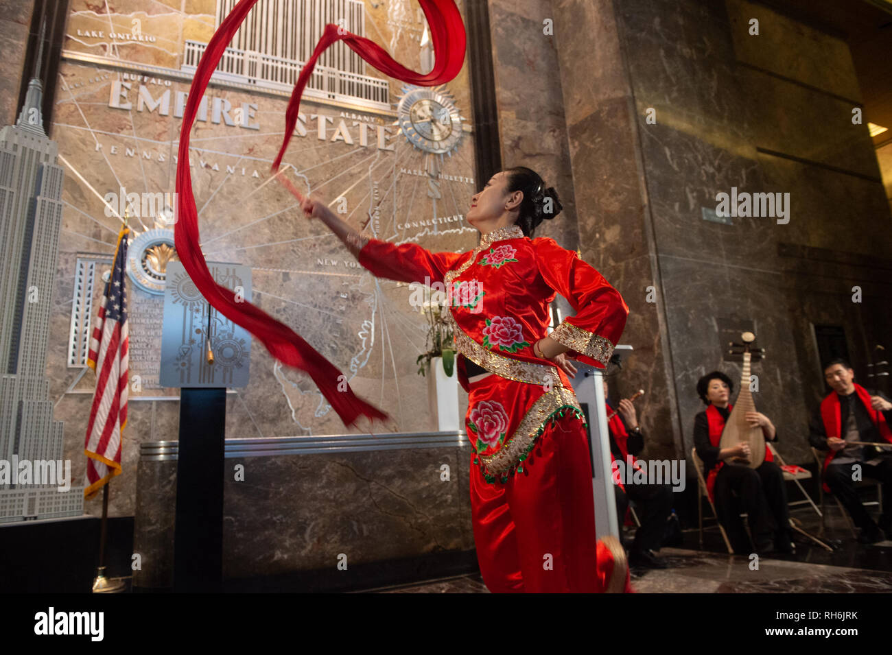 New York, New York, USA. 1 Feb, 2019. Eine Frau führt einen traditionellen Tanz wie das Empire State Realty Trust President und Chief Operating Officer John Kessler und Chinesische Generalkonsul HUANG PING Licht das Empire State Building das lunare Jahr des Schweins am Februar 1, 2019 in New York die Credit zu feiern: Bryan Smith/ZUMA Draht/Alamy leben Nachrichten Stockfoto