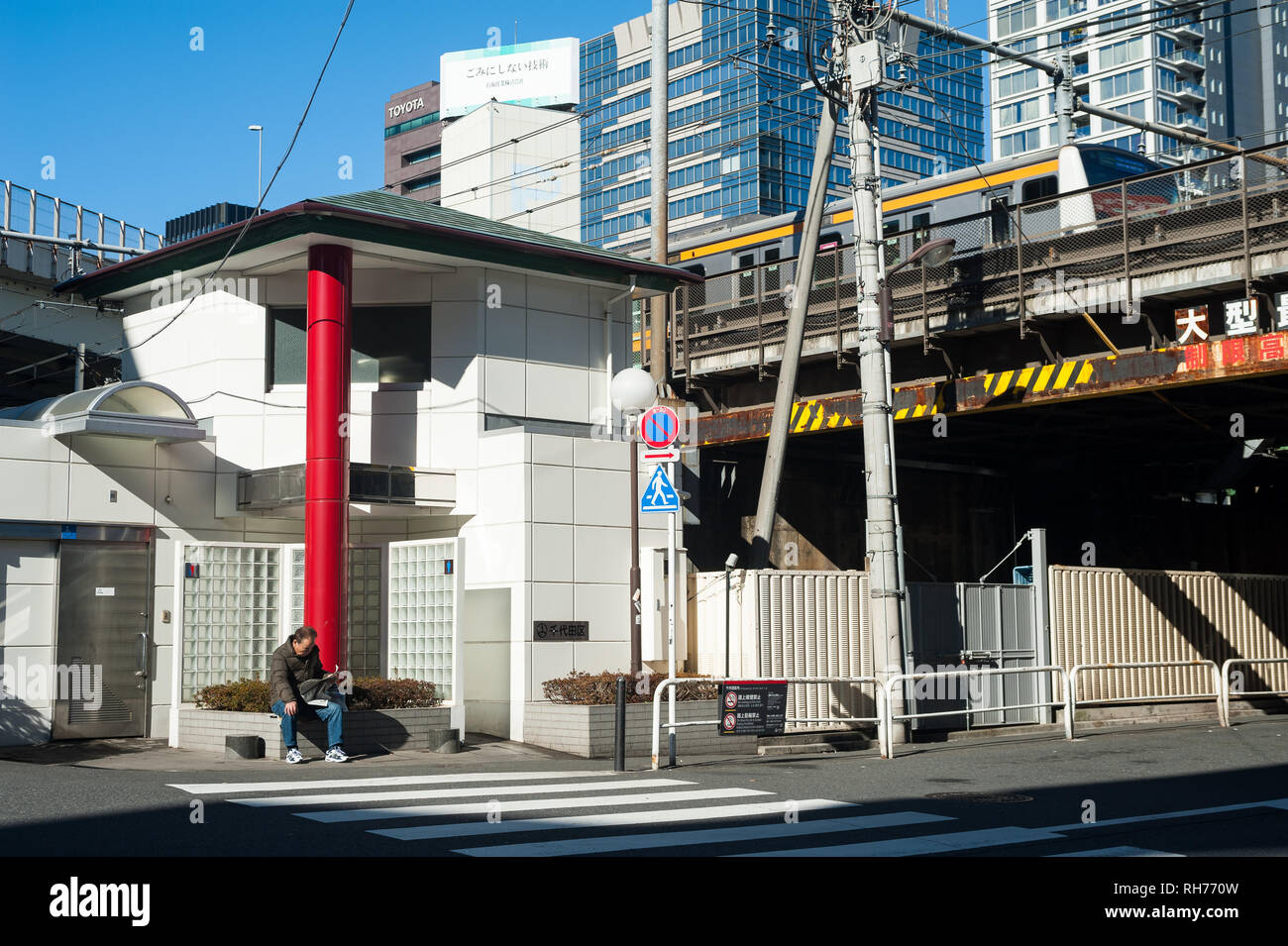 01.01.2018, Tokyo, Japan, Asien - ein Mann sitzt vor einem öffentlichen Wc und ist eine Zeitung lesen. Stockfoto