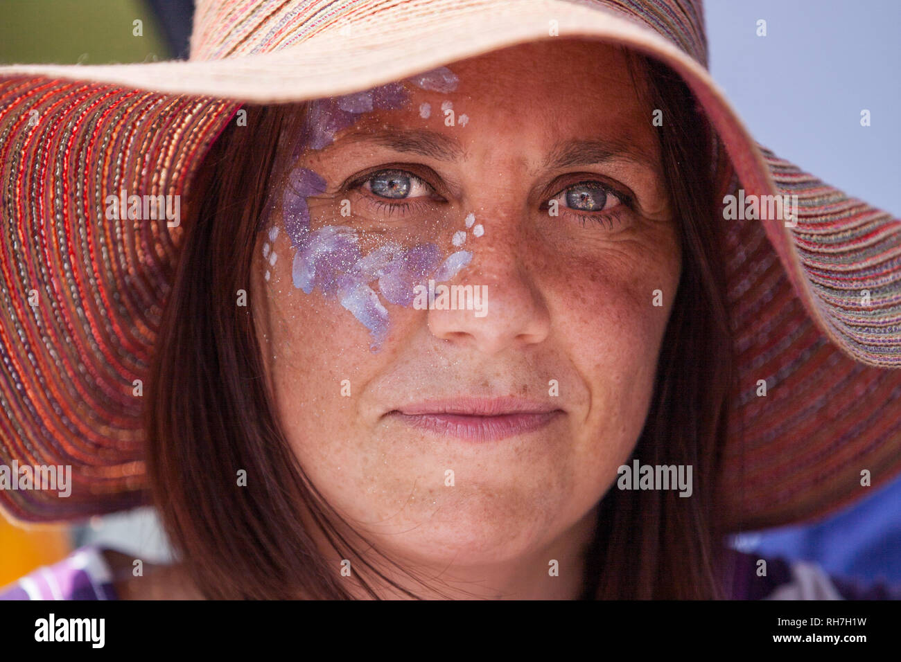 Nahaufnahme von Frau mit großen Hut mit Gesicht Farbe im Music Festival im Sommer Stockfoto