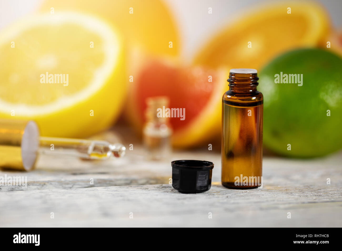 Zitrone ätherisches Öl Flasche und Früchte Stockfoto
