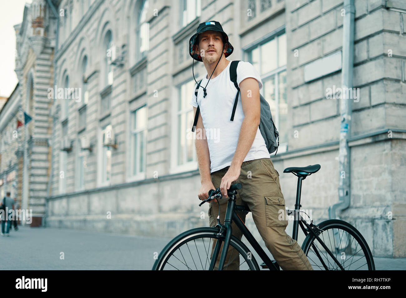 Ein Mann mit dem Fahrrad in einem alten europäischen Stadt im Freien. Lifestyle, ökologischen Verkehr, Personen Konzept. Stockfoto