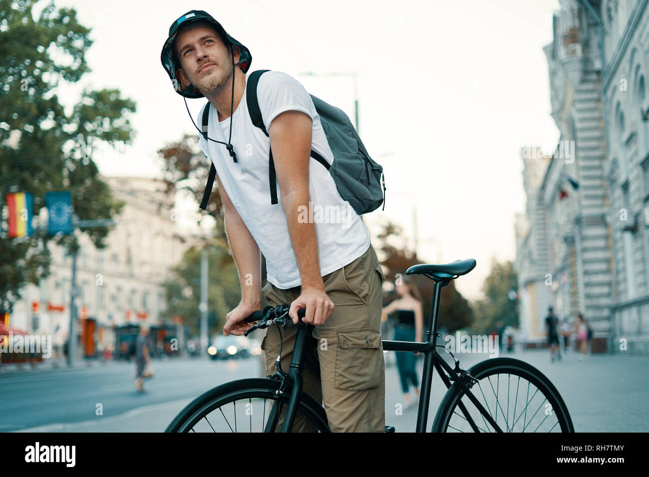 Ein Mann mit dem Fahrrad in einem alten europäischen Stadt im Freien. Lifestyle, ökologischen Verkehr, Personen Konzept. Stockfoto