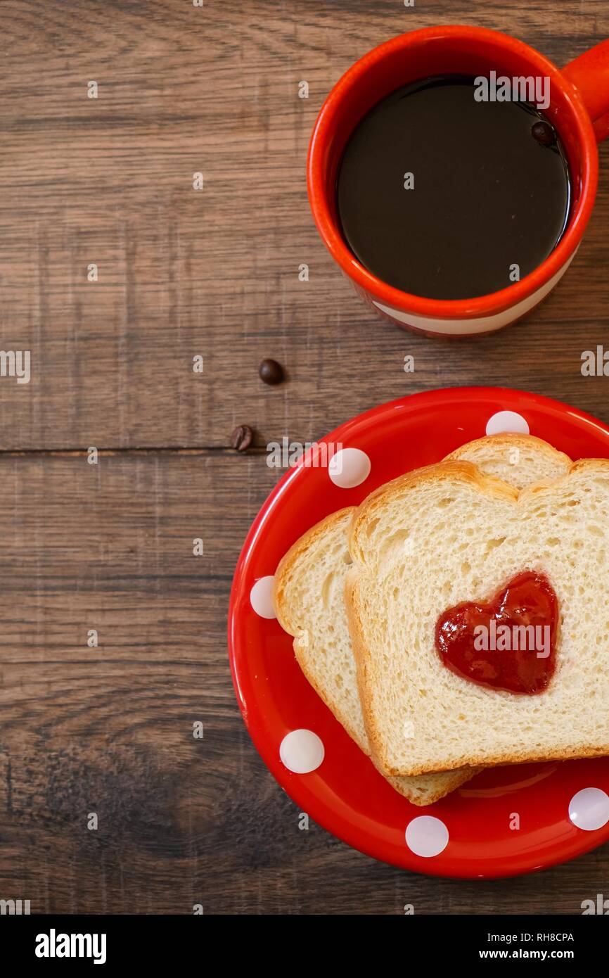 Valentines Tag Frühstück im Bett Sandwich mit roter Marmelade Herz/Cookies auf einem weißen trayon rote Platte, Ansicht von oben Stockfoto