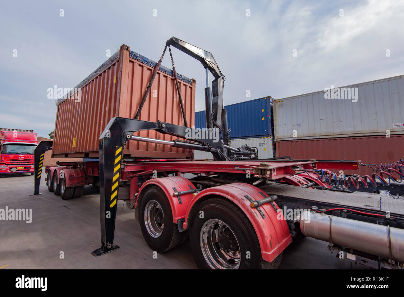 Eine seitliche Heber oder Seitenstapler Anhänger entladen einen Transportbehälter in einem Lkw-Hof in Sydney, Australien Stockfoto