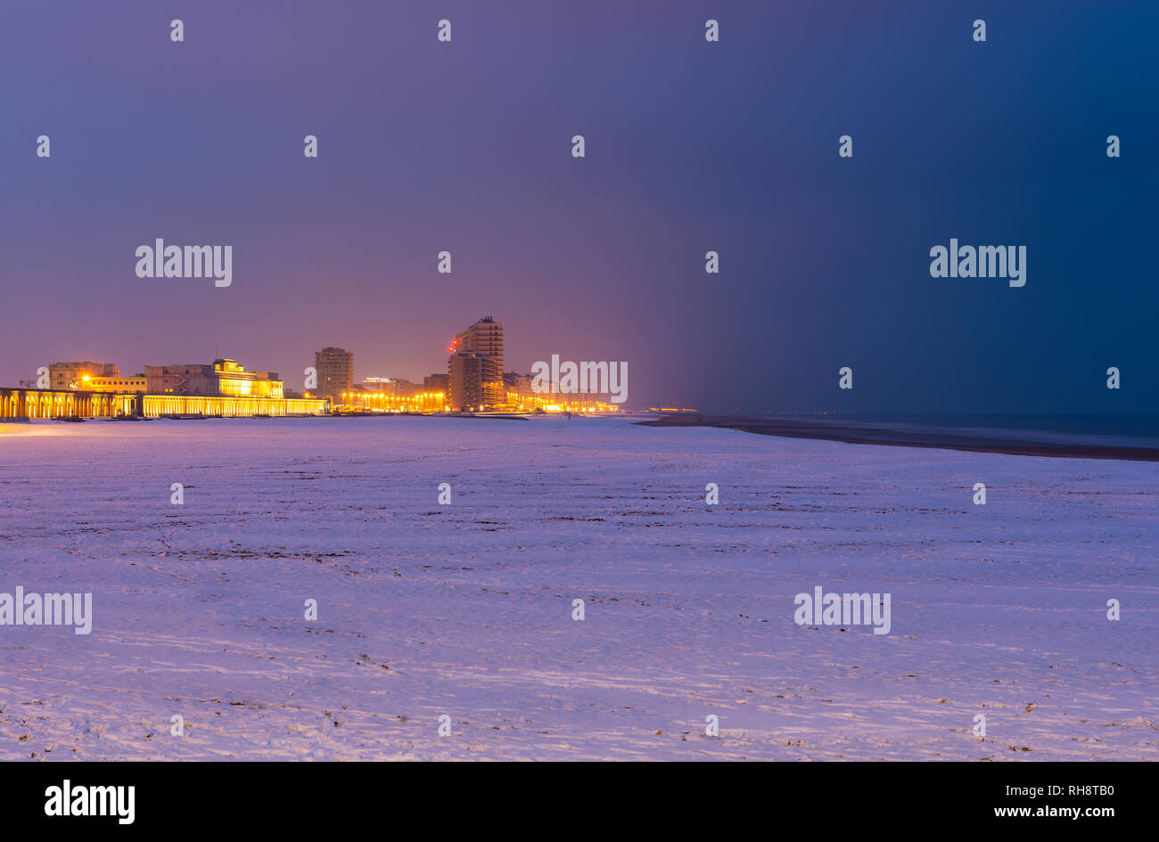 Stadtbild von Oostende (Ostende) mit schneebedeckten Strand im Winter und Nordsee zur blauen Stunde, Belgien. Stockfoto