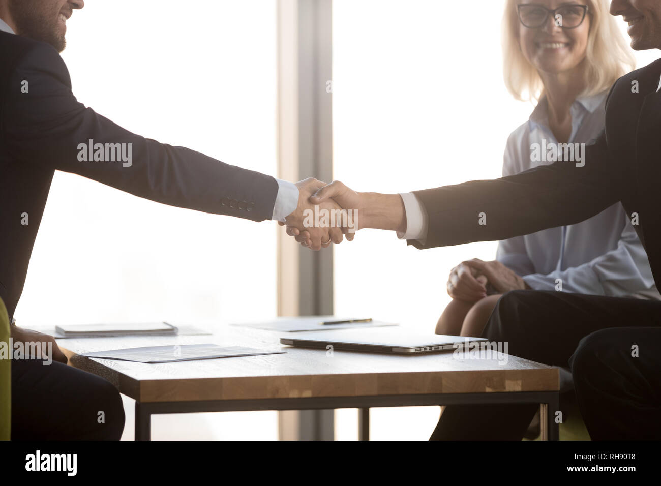 Zufriedene Geschäftspartner in Anzügen Hände schütteln, Ansicht schließen Stockfoto