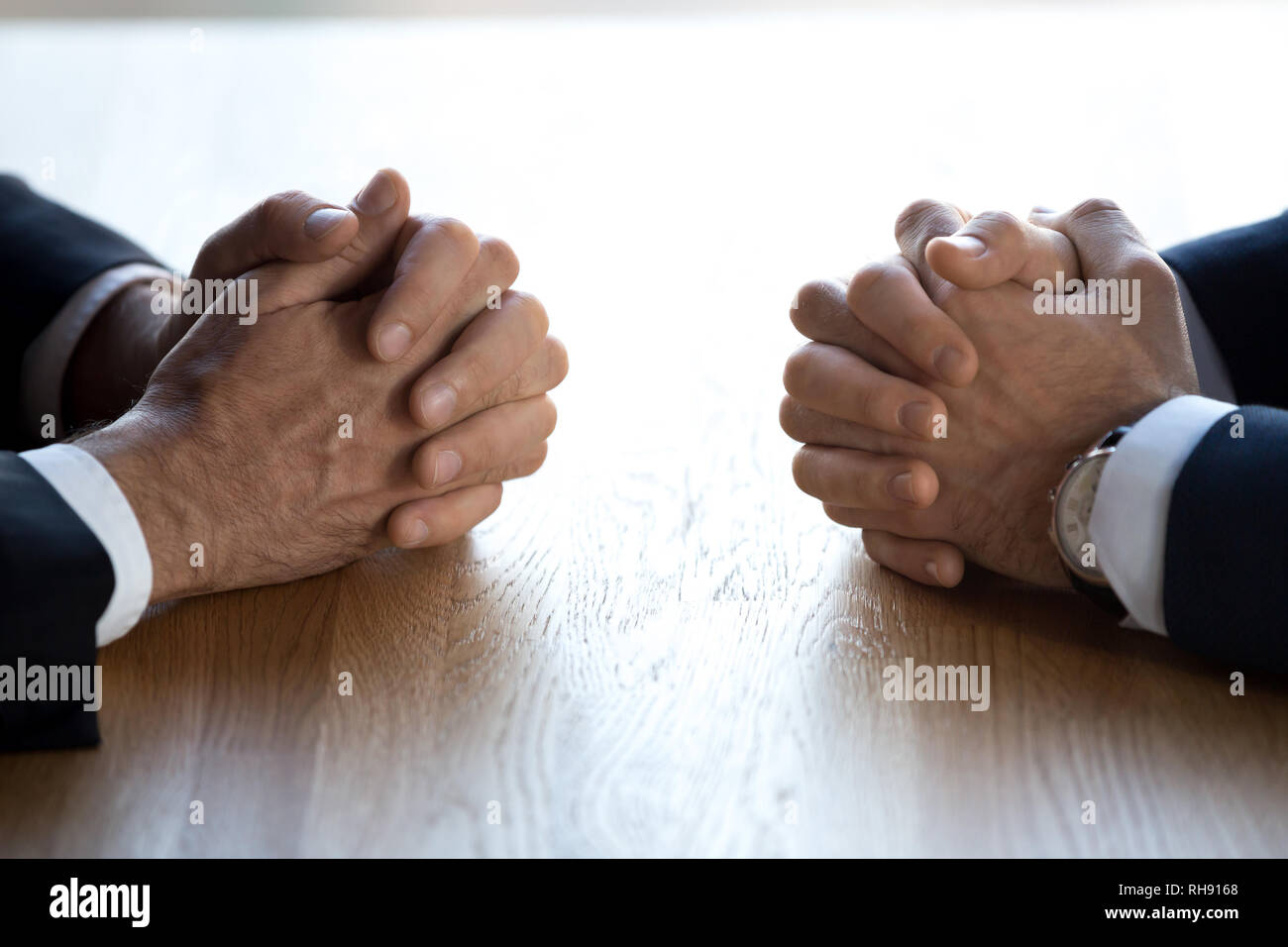 Gefalteten Händen von zwei Geschäftsmänner Verhandlungsführer Gegner gegenüber am Tisch Stockfoto