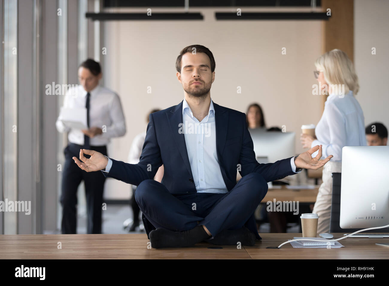 Ruhe Geschäftsmann in Anzug meditieren im Büro am Schreibtisch Stockfoto