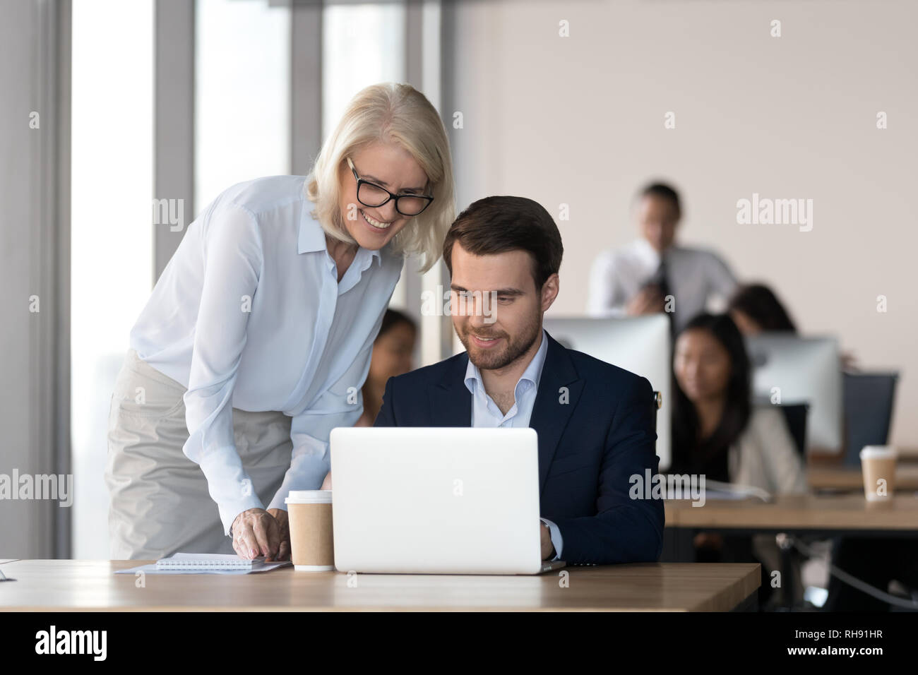 Freundlich mentor Training der Mitarbeiter im Büro mit Computer arbeiten Stockfoto