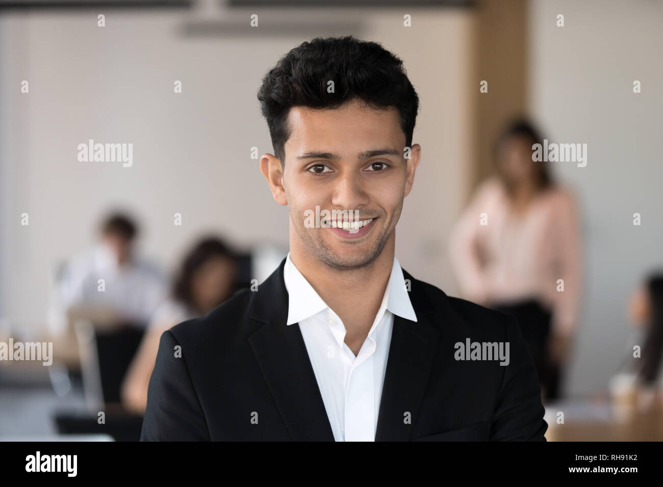 Junge lächelnde arabisch Teamleiter im Anzug an Kamera suchen Stockfoto