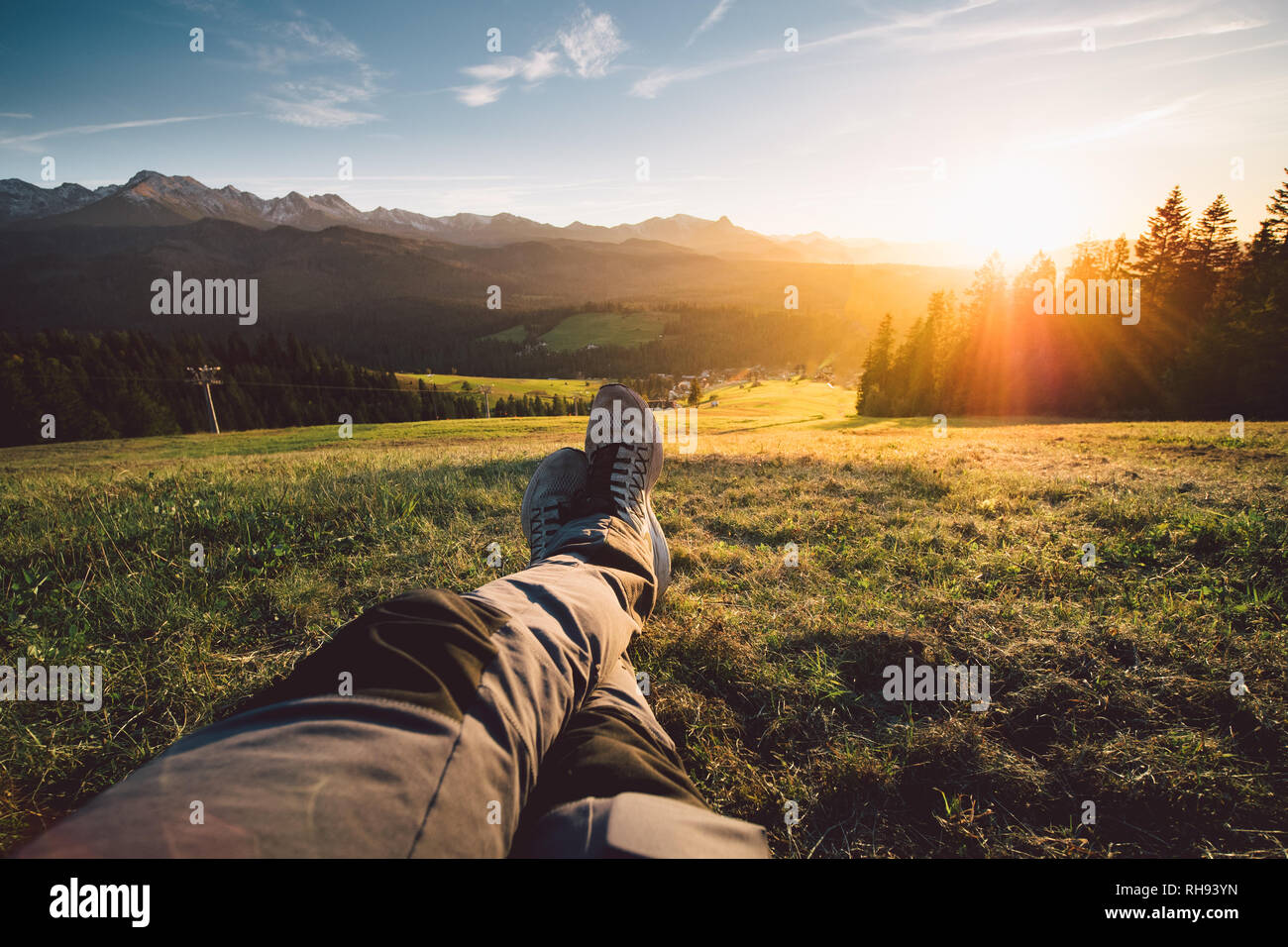 POV eines Mannes liegen auf einer Wiese in den Bergen Stockfoto