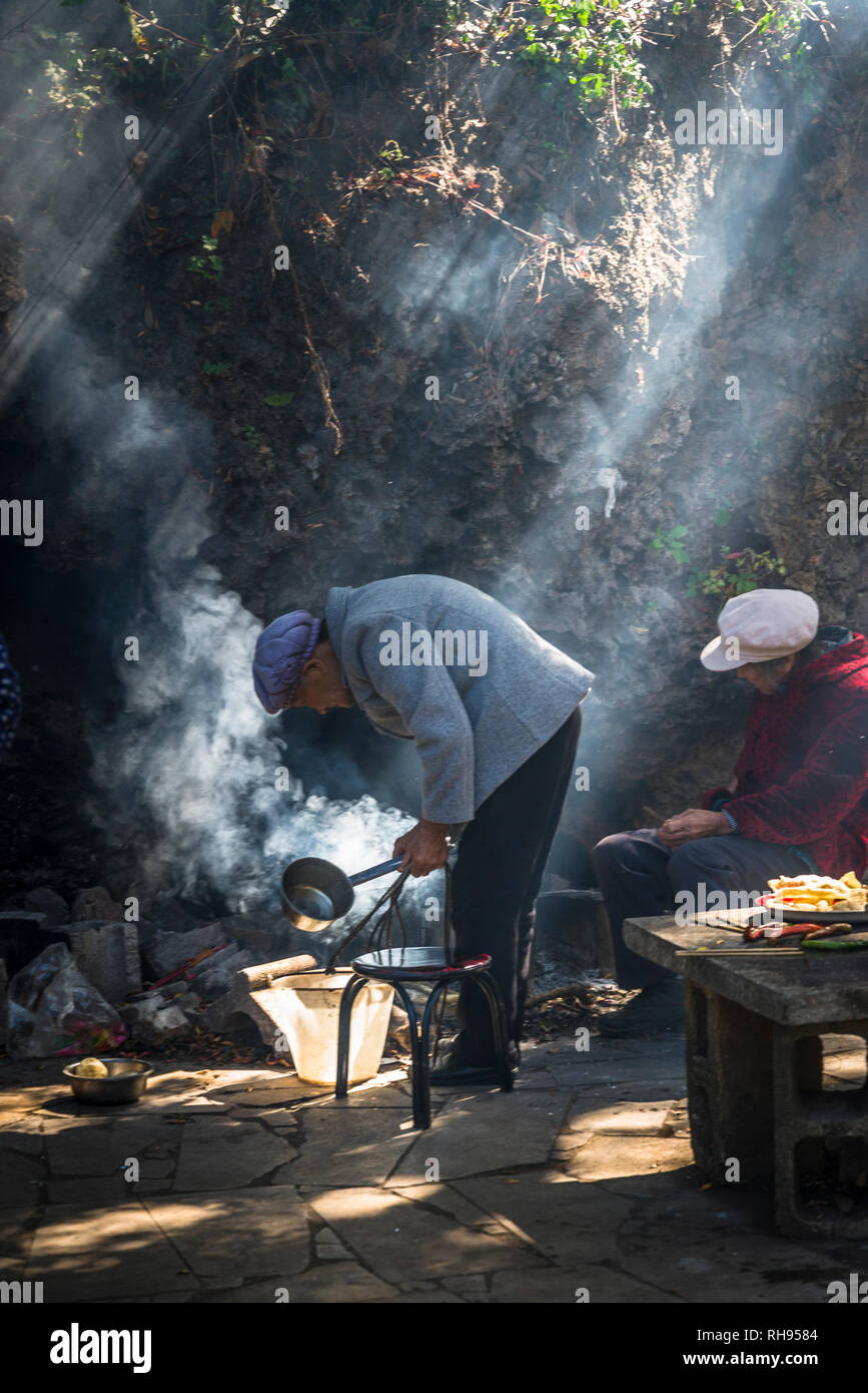 Frau Kochen bei White Dragon Pool Schrein nahe Shaxi historische Marktstadt, Yunnan, China Stockfoto