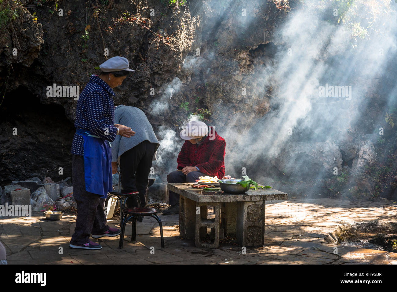 Frau Kochen bei White Dragon Pool Schrein nahe Shaxi historische Marktstadt, Yunnan, China Stockfoto