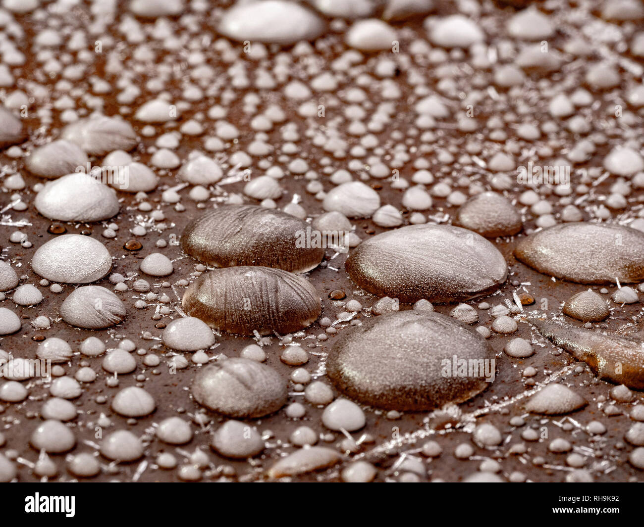 Gefrorene Wassertropfen auf Stahl Garten Tisch. Stockfoto