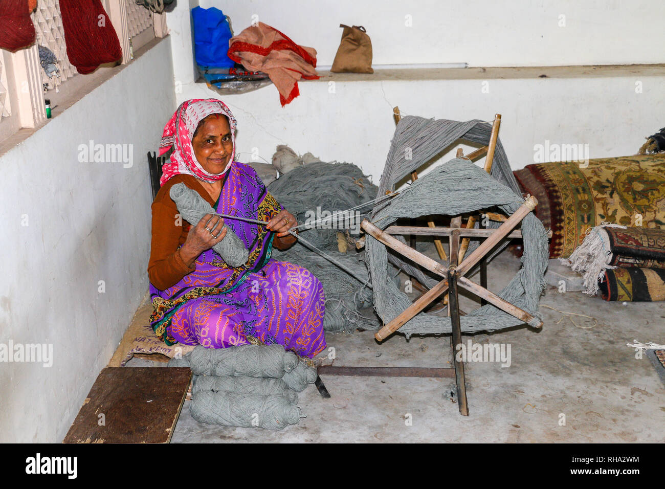Indische Frau Spinnen von Wolle, auf ein Spinnrad, Teppiche in Jaipur, Rajasthan, Indien, Asien Stockfoto