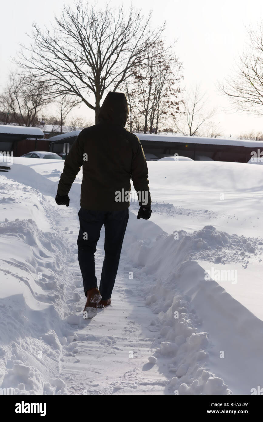 Mann geht in den Schnee Stockfoto