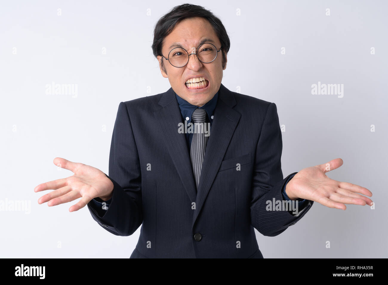 Portrait von verwirrt japanischen Geschäftsmann in Anzug Achselzucken Stockfoto