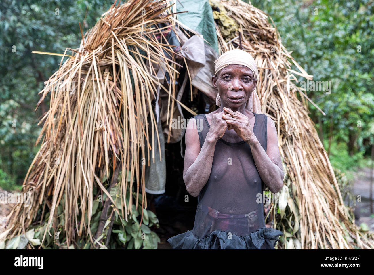 Portrait von Pygmy tribeswoman stand vor der primitiven Hütte, Uganda Stockfoto