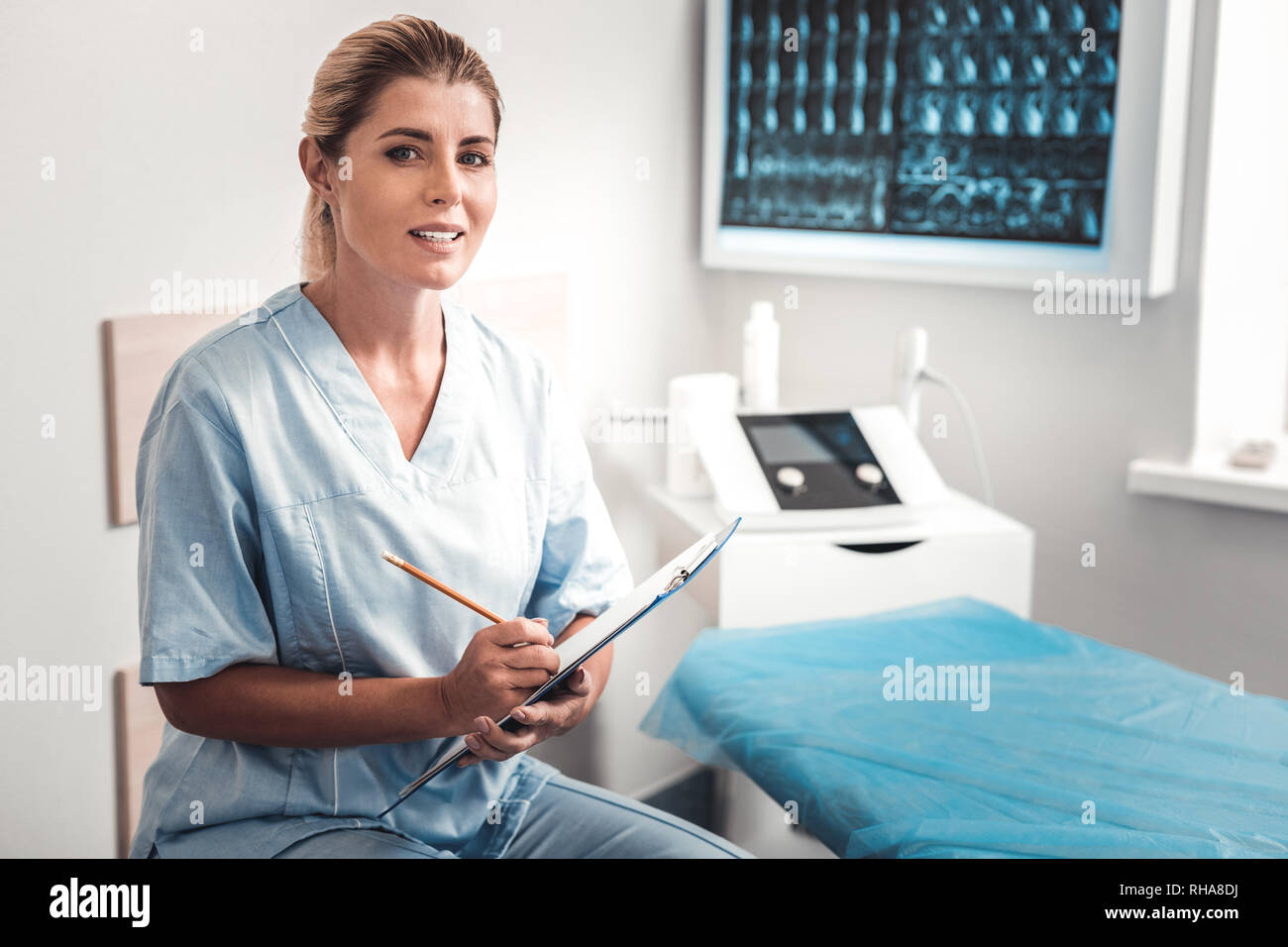 Lächelnd angenehme weibliche Arzt Notizen zu machen Stockfoto