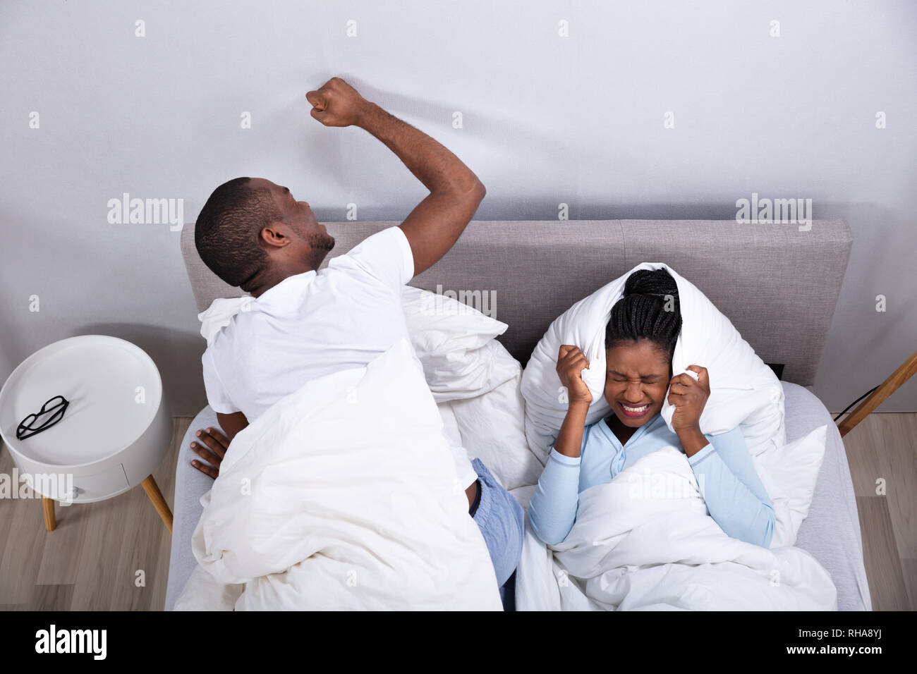 Eine Ansicht von Paar liegend auf Bett gestört durch Lärm Stockfoto