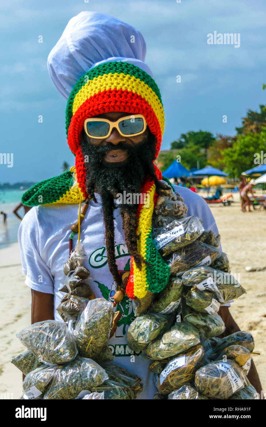 Negril, Jamaika - 13. Juli 2014: jamaikanischen Rastafari mann Kräuter verkaufen am Strand von Negril. Stockfoto
