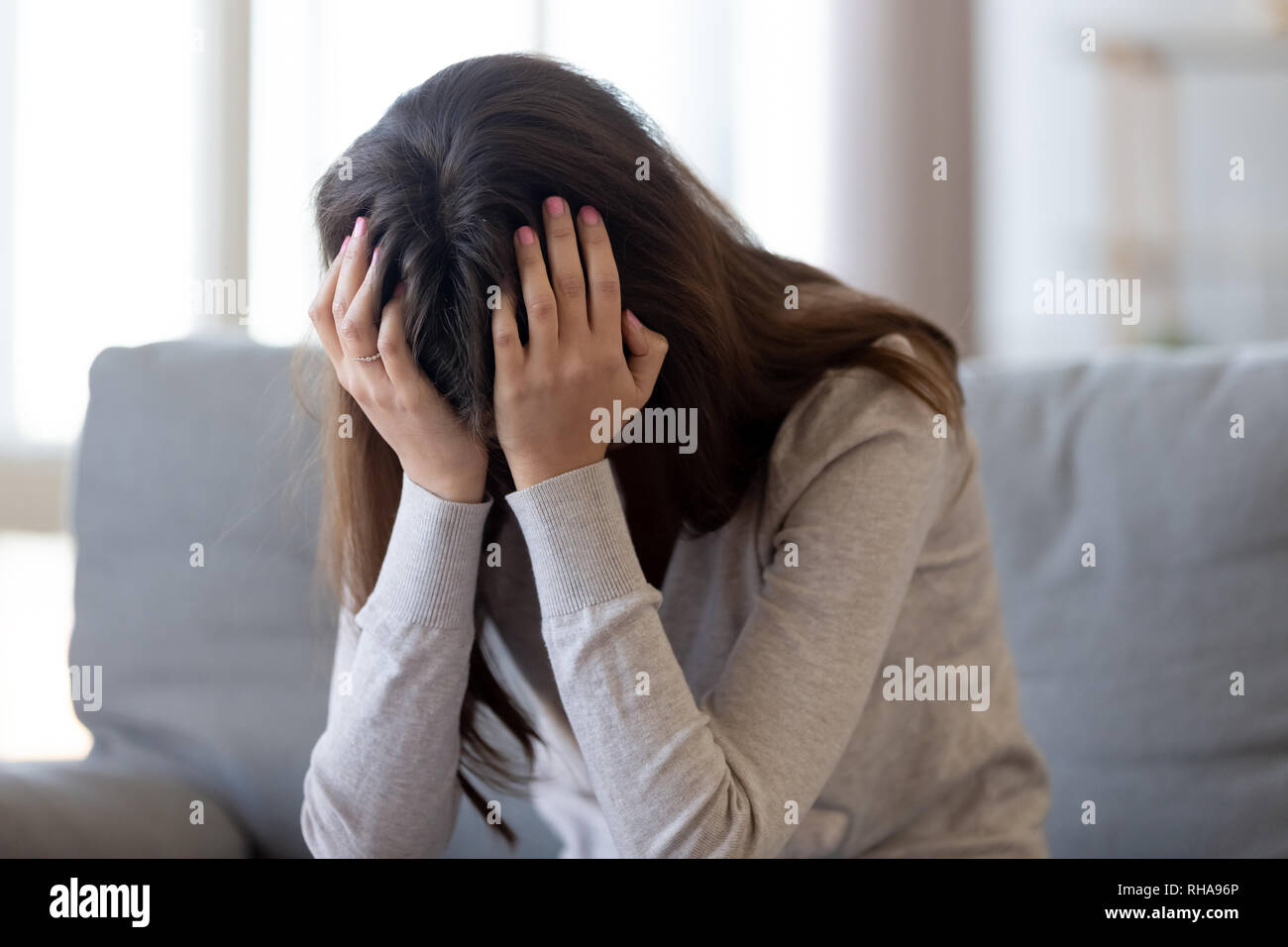 Deprimiert junge Frau mit Kopf in den Händen Gefühl verletzt umgekippt Stockfoto
