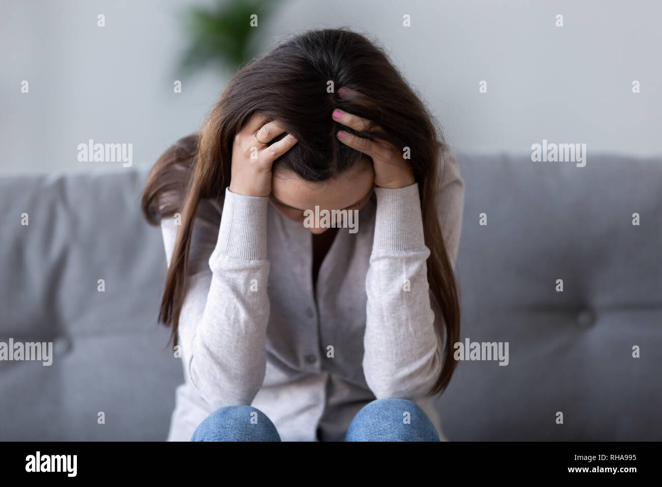 Junge Frau deprimiert einsam leiden unter Kopfschmerzen verletzt umgekippt Stockfoto