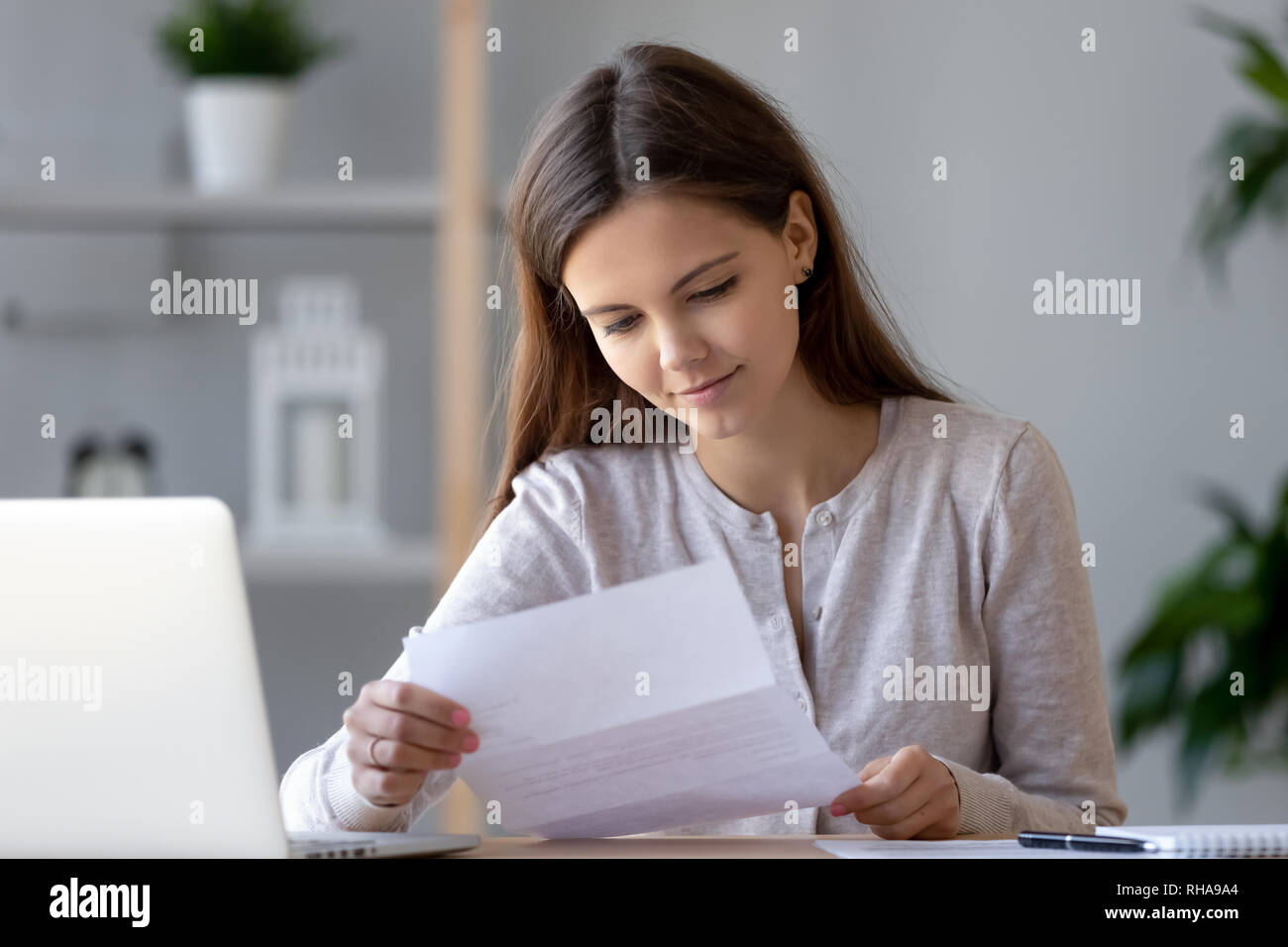 Lächelnden jungen Frau tun Papierkram lesen schreiben oder Bill Stockfoto