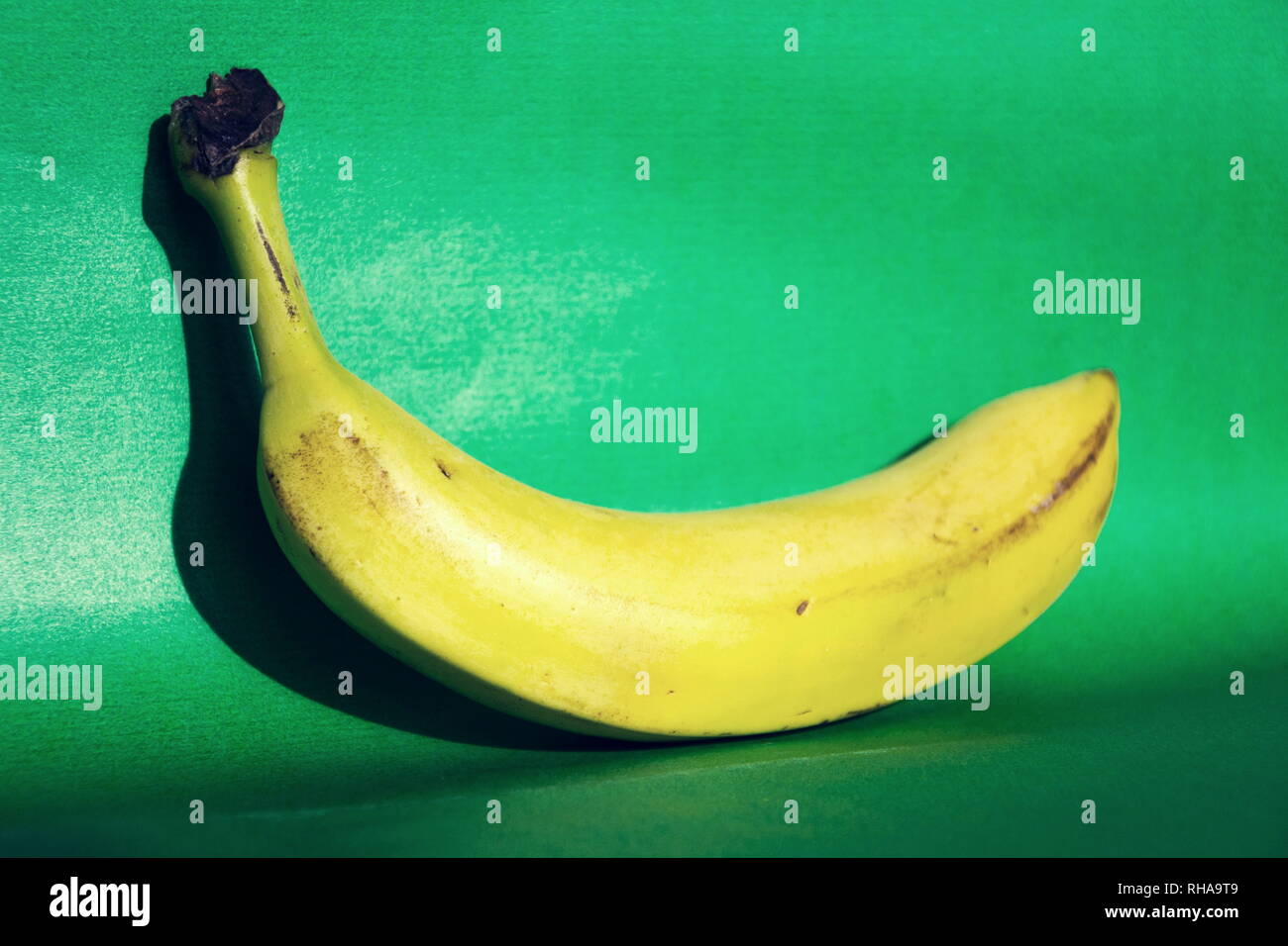 Gelbe frischen Bananen liegen auf grünem Hintergrund isoliert, gesunde Ernährung Stockfoto