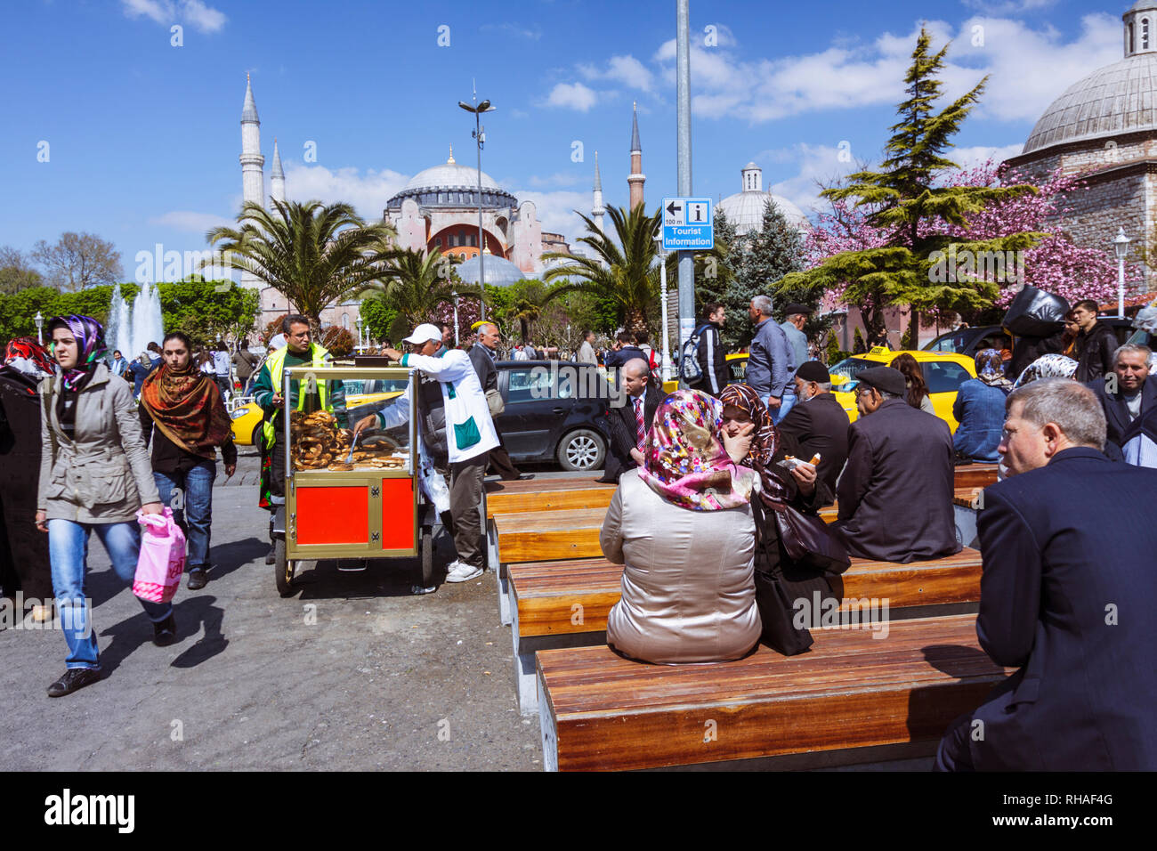 Istanbul, Türkei: Menschen sitzen auf Sultanahmet Platz mit der Hagia Sophia im Hintergrund. Stockfoto