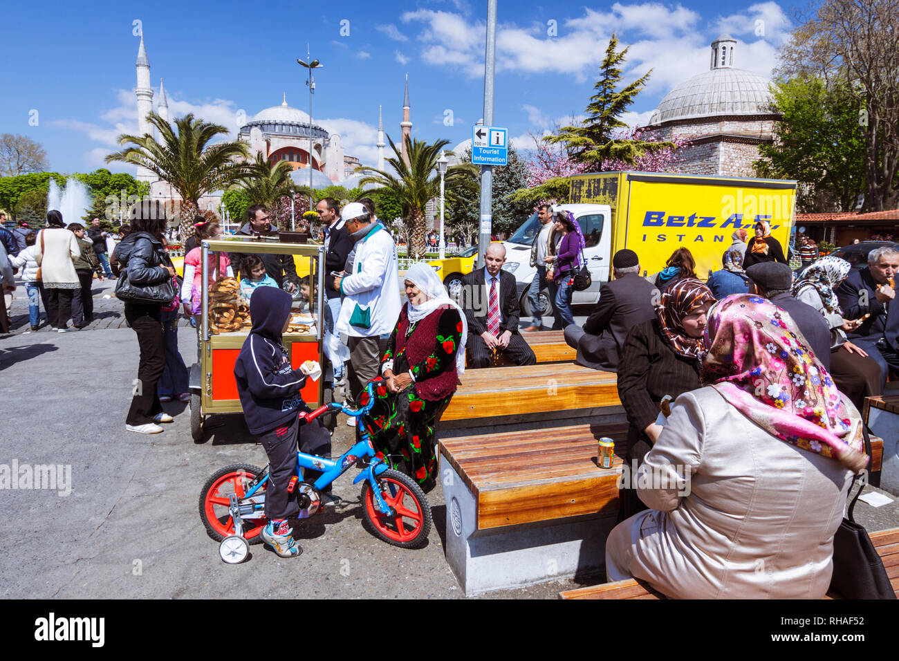 Istanbul, Türkei: Menschen sitzen auf Sultanahmet Platz mit der Hagia Sophia im Hintergrund. Stockfoto